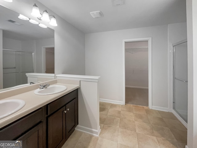 full bath featuring a stall shower, baseboards, visible vents, and a sink