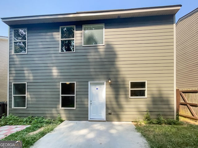 rear view of house featuring a patio and fence