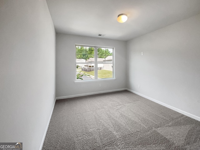 unfurnished room featuring carpet, visible vents, and baseboards