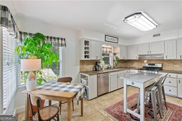 kitchen featuring light tile patterned floors, range, decorative backsplash, and dishwasher