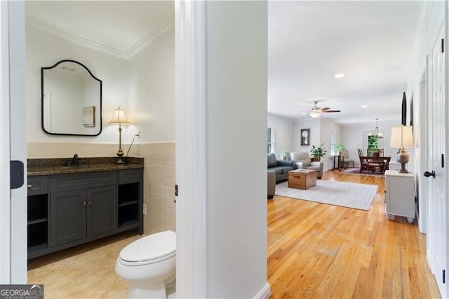 bathroom featuring ceiling fan, wood-type flooring, toilet, and vanity