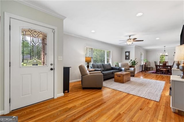 living room featuring ceiling fan, light hardwood / wood-style flooring, and crown molding