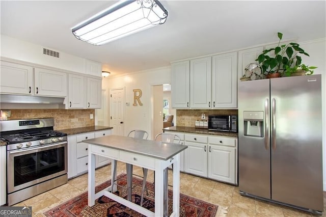 kitchen with light tile patterned flooring, backsplash, stainless steel appliances, and white cabinetry