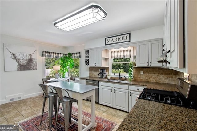 kitchen featuring decorative backsplash, stainless steel dishwasher, and light tile patterned floors