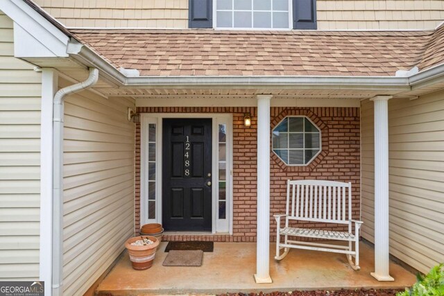 view of exterior entry featuring covered porch