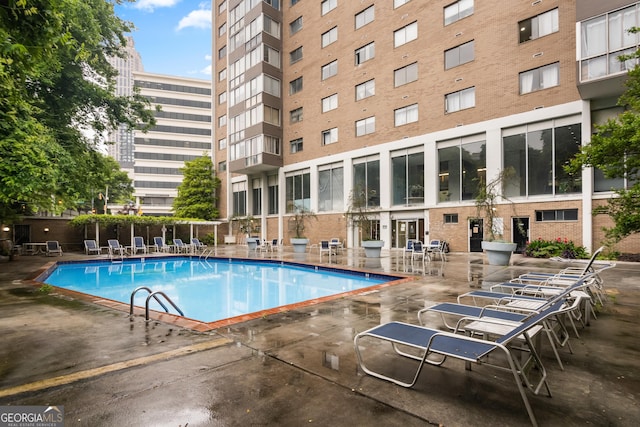 community pool featuring a patio and fence