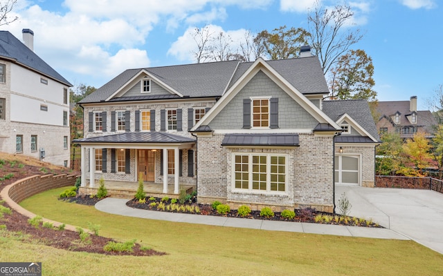 view of front of house with a porch, a garage, and a front lawn