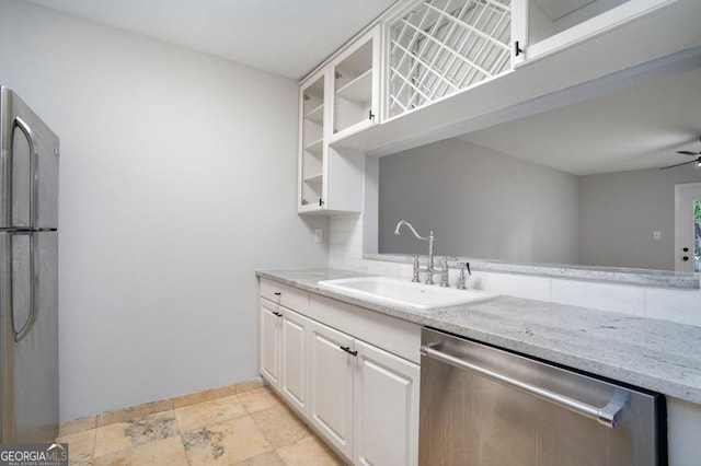 kitchen featuring sink, white cabinetry, light stone counters, ceiling fan, and stainless steel appliances