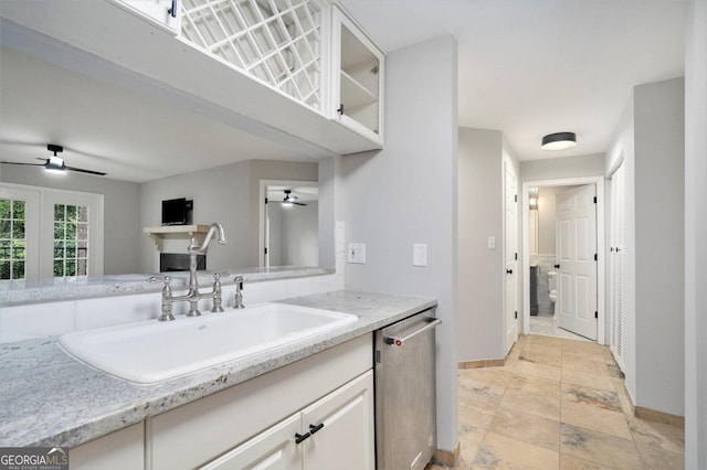 kitchen with ceiling fan, stainless steel dishwasher, sink, and light stone counters