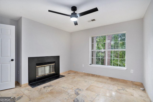 unfurnished living room with ceiling fan and light tile patterned flooring