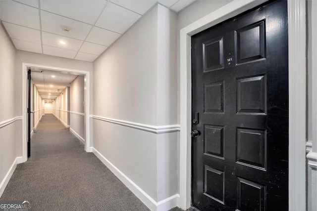 hallway with carpet and a drop ceiling