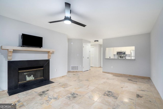 unfurnished living room featuring ceiling fan and light tile patterned flooring