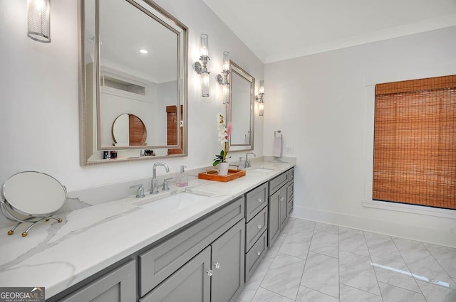 bathroom with a sink, marble finish floor, ornamental molding, and double vanity