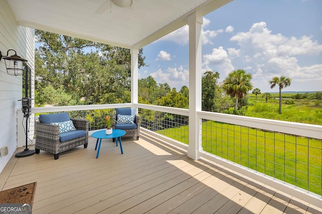 deck featuring ceiling fan and a yard