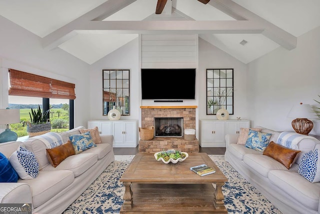 living area with beamed ceiling, high vaulted ceiling, a brick fireplace, and wood finished floors