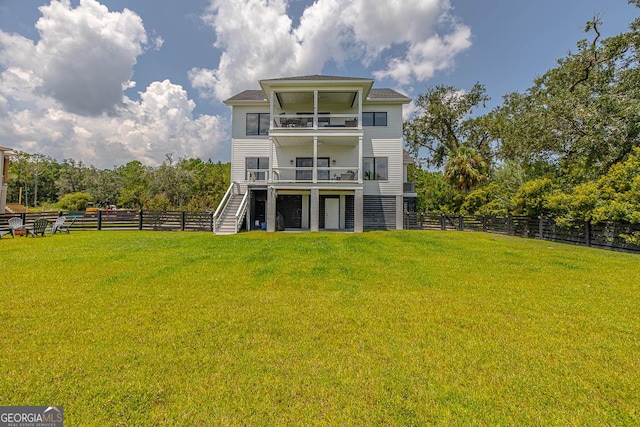 back of house featuring stairs, a lawn, and fence