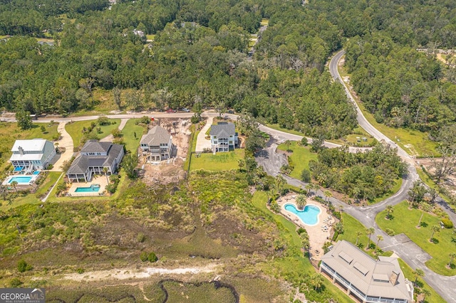 birds eye view of property featuring a wooded view