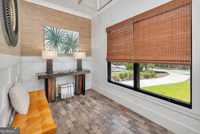 interior space with wainscoting and brick floor