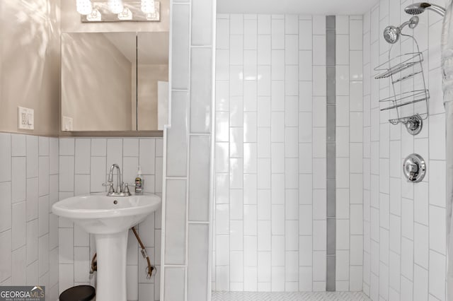 bathroom featuring tile walls, tiled shower, and decorative backsplash