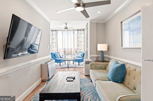 living room with light wood-type flooring, a wealth of natural light, ornamental molding, and ceiling fan