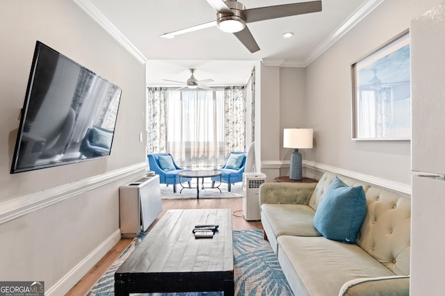 living room with baseboards, crown molding, and light wood finished floors