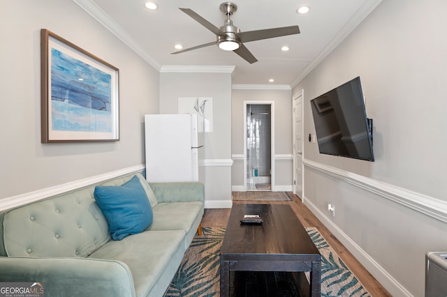 living room featuring hardwood / wood-style floors, crown molding, and ceiling fan