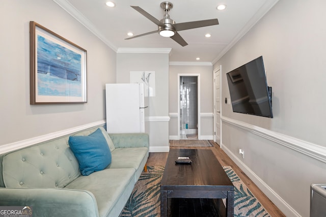 living room featuring ornamental molding, recessed lighting, baseboards, and wood finished floors