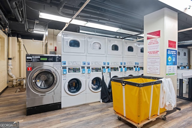 community laundry room featuring independent washer and dryer, wood finished floors, and stacked washer / drying machine