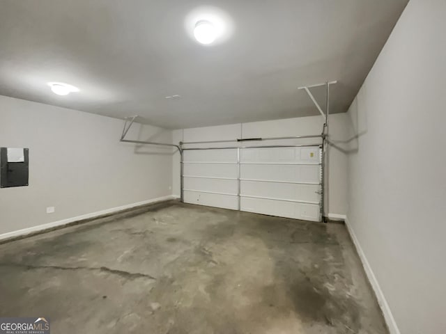 garage featuring electric panel and baseboards