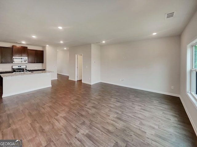 unfurnished living room with light wood finished floors, baseboards, and recessed lighting