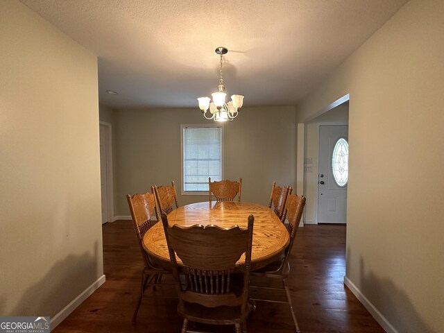 dining area featuring dark hardwood / wood-style flooring, a notable chandelier, and a wealth of natural light