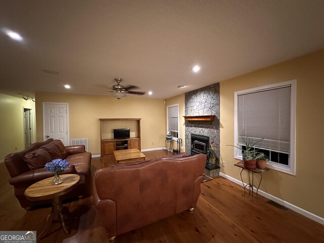 living room with a fireplace, ceiling fan, and hardwood / wood-style floors