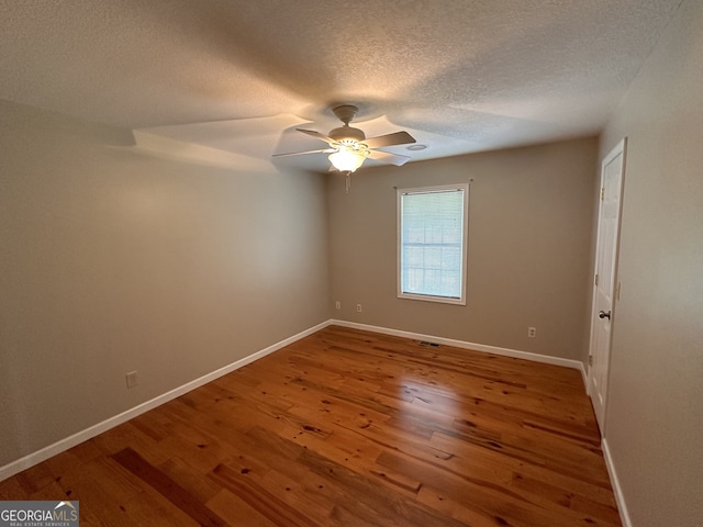 spare room with a textured ceiling, ceiling fan, and hardwood / wood-style flooring