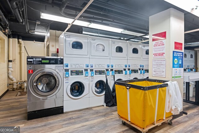 laundry room featuring washer and dryer, wood-type flooring, and stacked washer / dryer