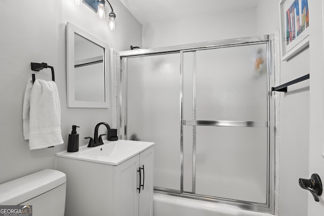 full bathroom with combined bath / shower with glass door, toilet, and vanity