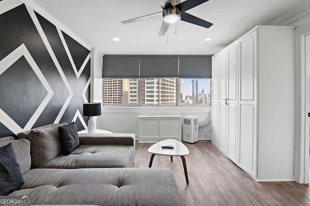 living area with a city view, light wood-type flooring, a ceiling fan, and recessed lighting