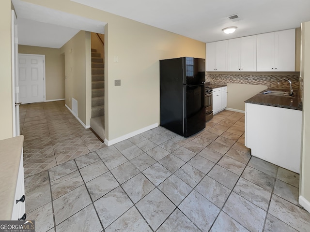 kitchen with visible vents, white cabinets, decorative backsplash, dark countertops, and freestanding refrigerator