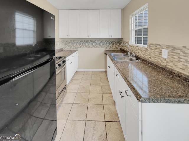 kitchen with appliances with stainless steel finishes, white cabinetry, decorative backsplash, and a sink