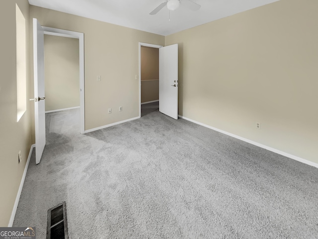 unfurnished bedroom featuring light carpet, baseboards, visible vents, and ceiling fan