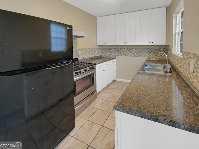 kitchen featuring stainless steel gas range, freestanding refrigerator, and white cabinets