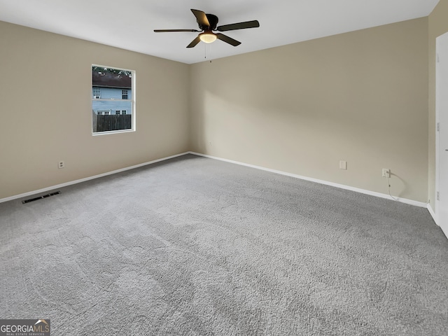 empty room with baseboards, carpet flooring, visible vents, and a ceiling fan