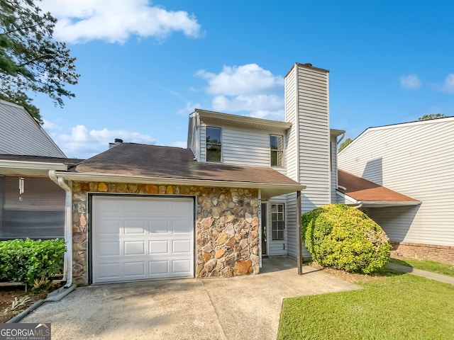 view of property featuring concrete driveway, stone siding, a chimney, roof with shingles, and an attached garage