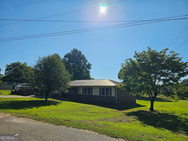 view of front of home with metal roof and a front yard