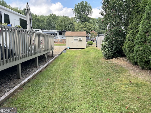 view of yard with a wooden deck and a storage shed