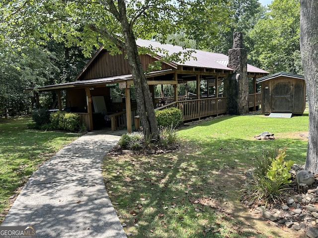 view of front of house featuring a front yard and a storage shed