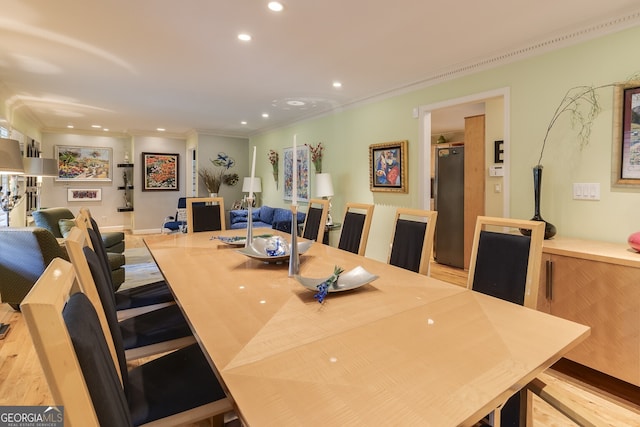 dining room with crown molding and light wood-type flooring