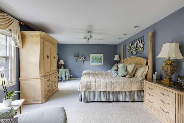 bedroom with ceiling fan, multiple windows, and light colored carpet