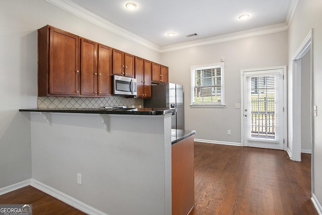 kitchen with stainless steel appliances, a kitchen breakfast bar, dark wood-type flooring, and kitchen peninsula