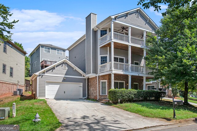 view of front of home featuring a garage, central AC unit, a front yard, a balcony, and ceiling fan