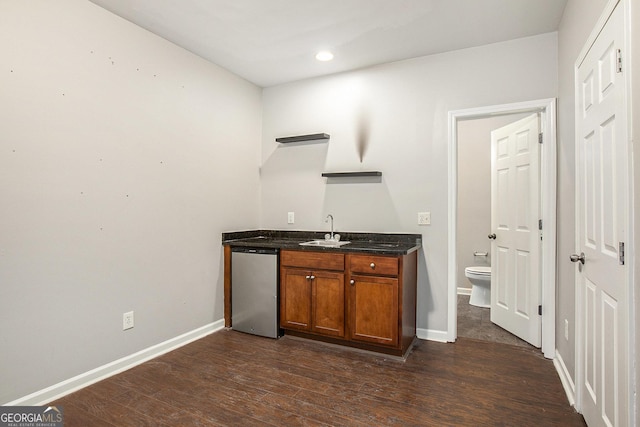 bar with sink, dark hardwood / wood-style flooring, and dishwasher